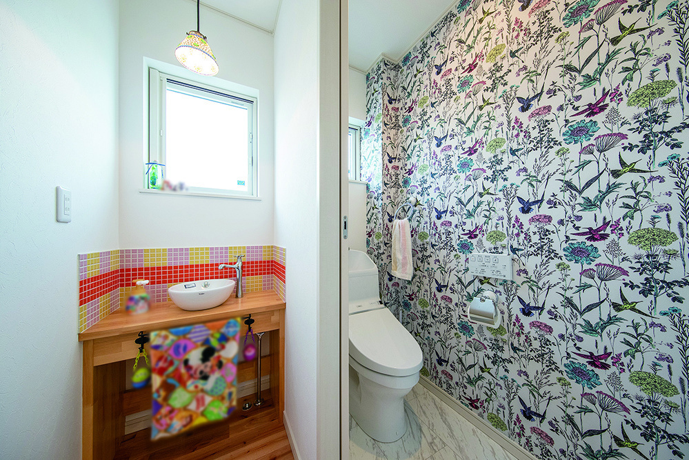 すまいポート21水戸・つくば施工事例　トイレの壁紙は大胆なデザイン柄にし  洗面台のタイルや照明もこだわった空間の写真